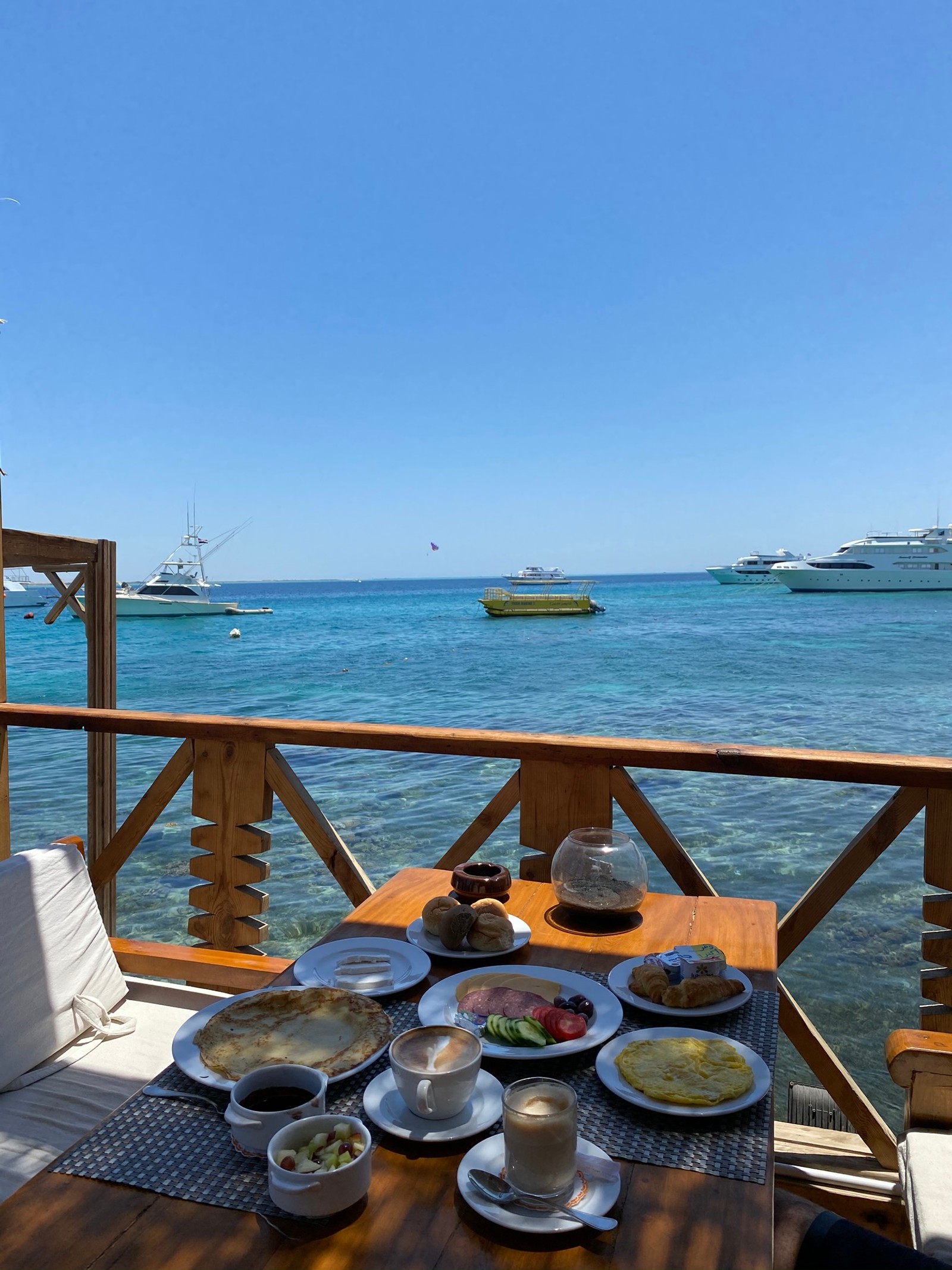 Há uma mesa com pratos de comida no convés (mar, barco, oceano, turismo, utensílios de servir)