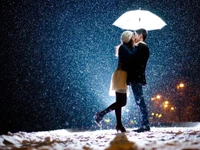 Beso romántico bajo un paraguas nevado