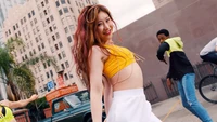 Chaeryeong from ITZY dancing joyfully in a vibrant urban setting.