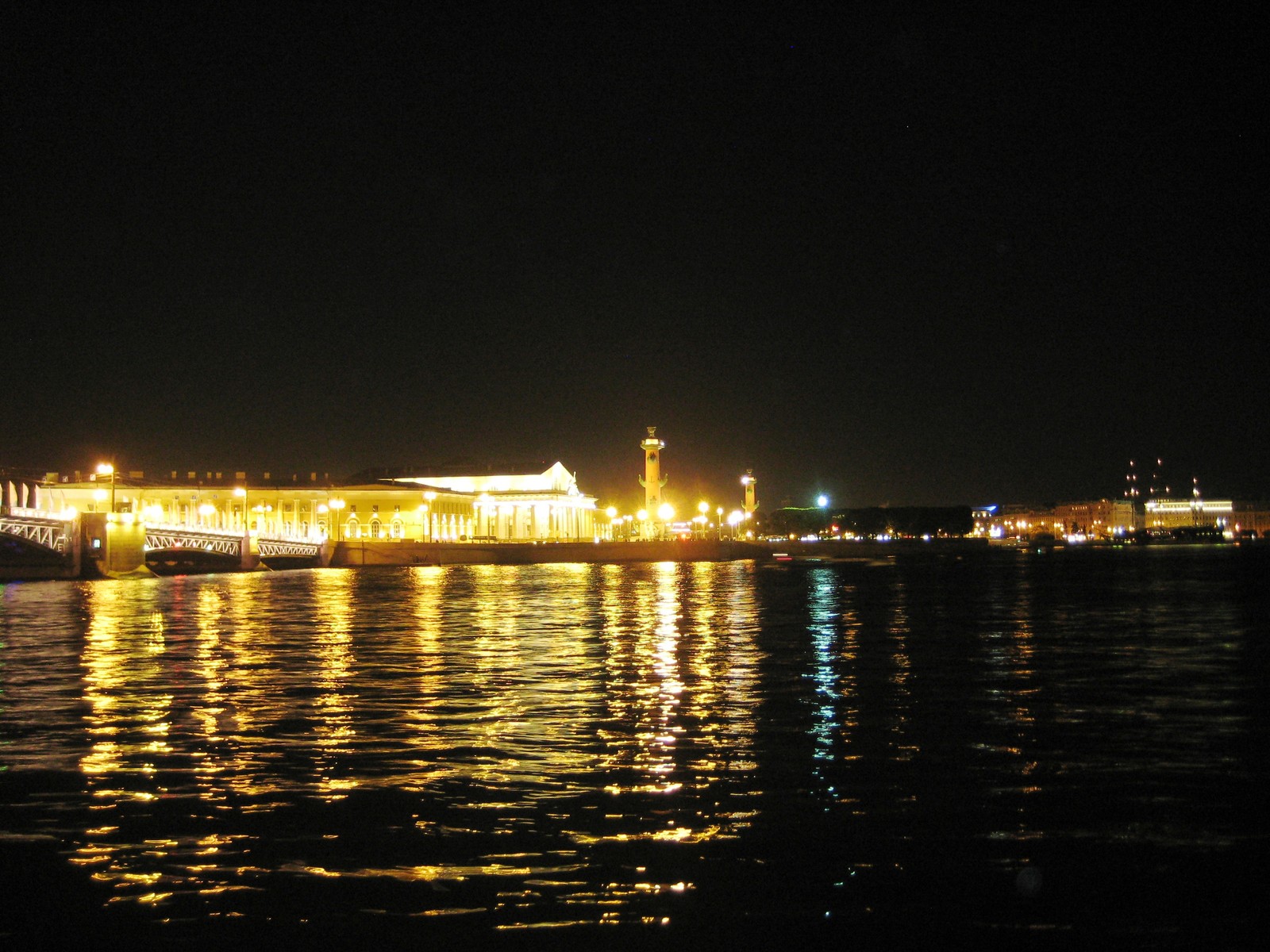 Vue nocturne d'un pont au-dessus d'un plan d'eau avec un bâtiment en arrière-plan (nuit, réflexion, eau, voie navigable, ville)