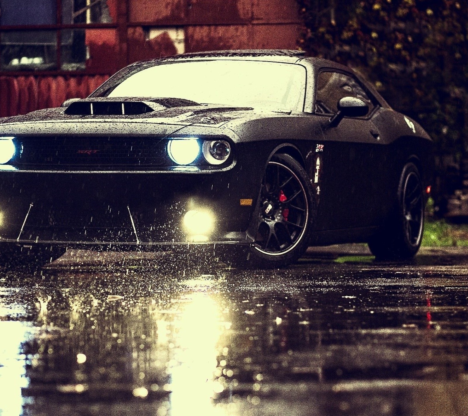 Um carro preto estacionado na chuva em uma rua molhada (dodge, chuva, srt)