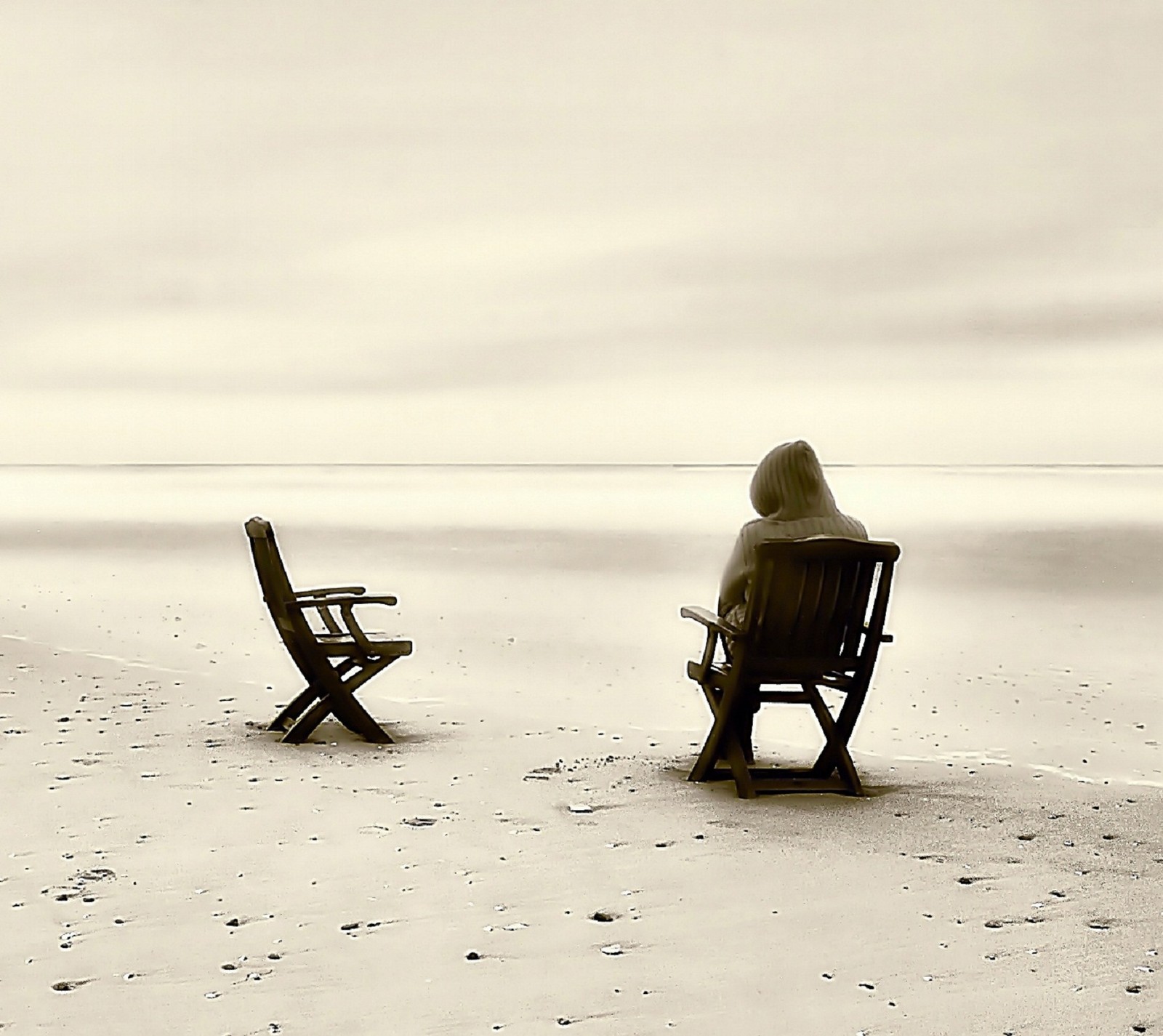 Hay una persona sentada en un banco en la playa (genial, solitario, fondo de pantalla)