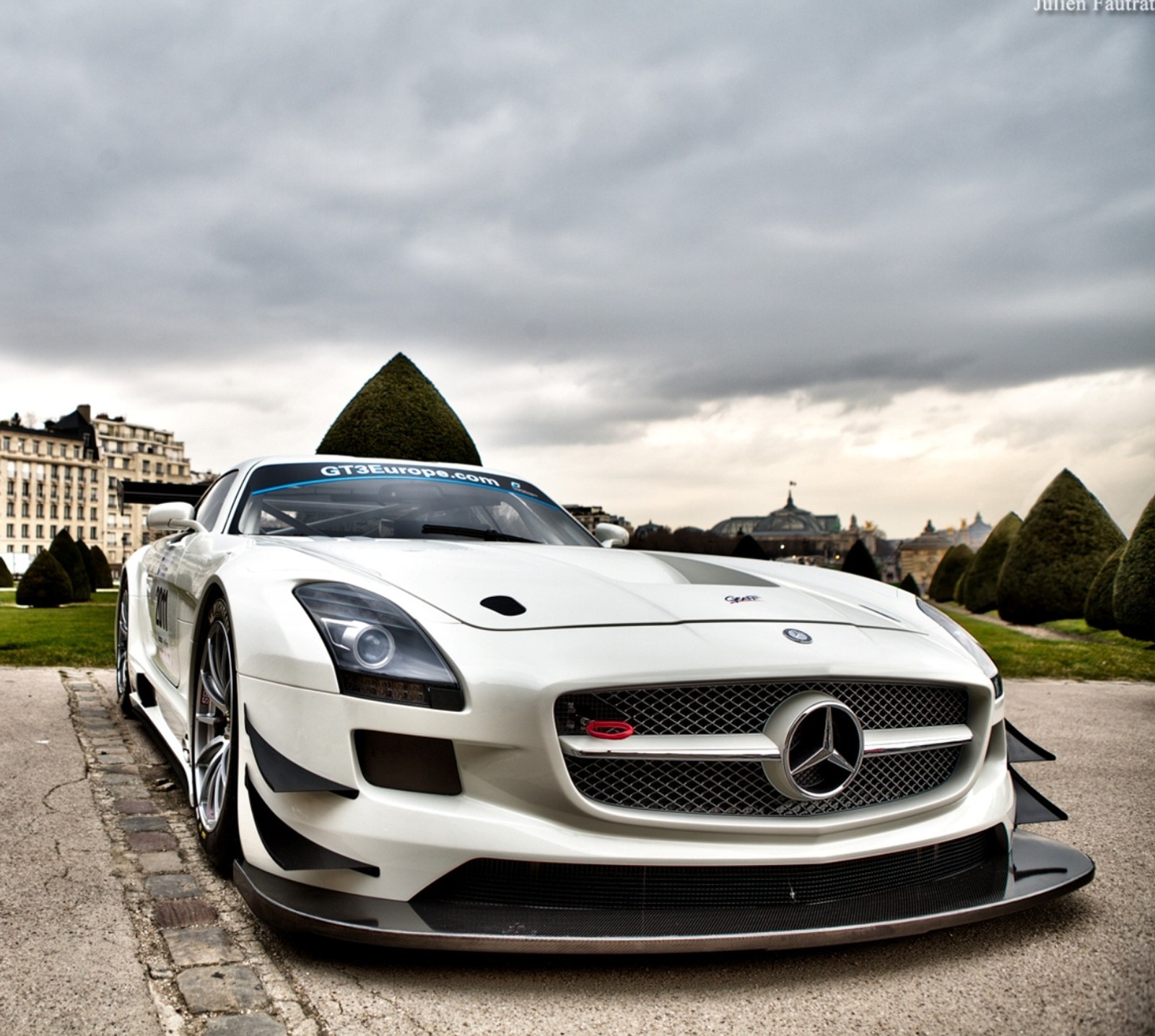 A close up of a white sports car parked in front of a building (auto, mercedes sls amg)