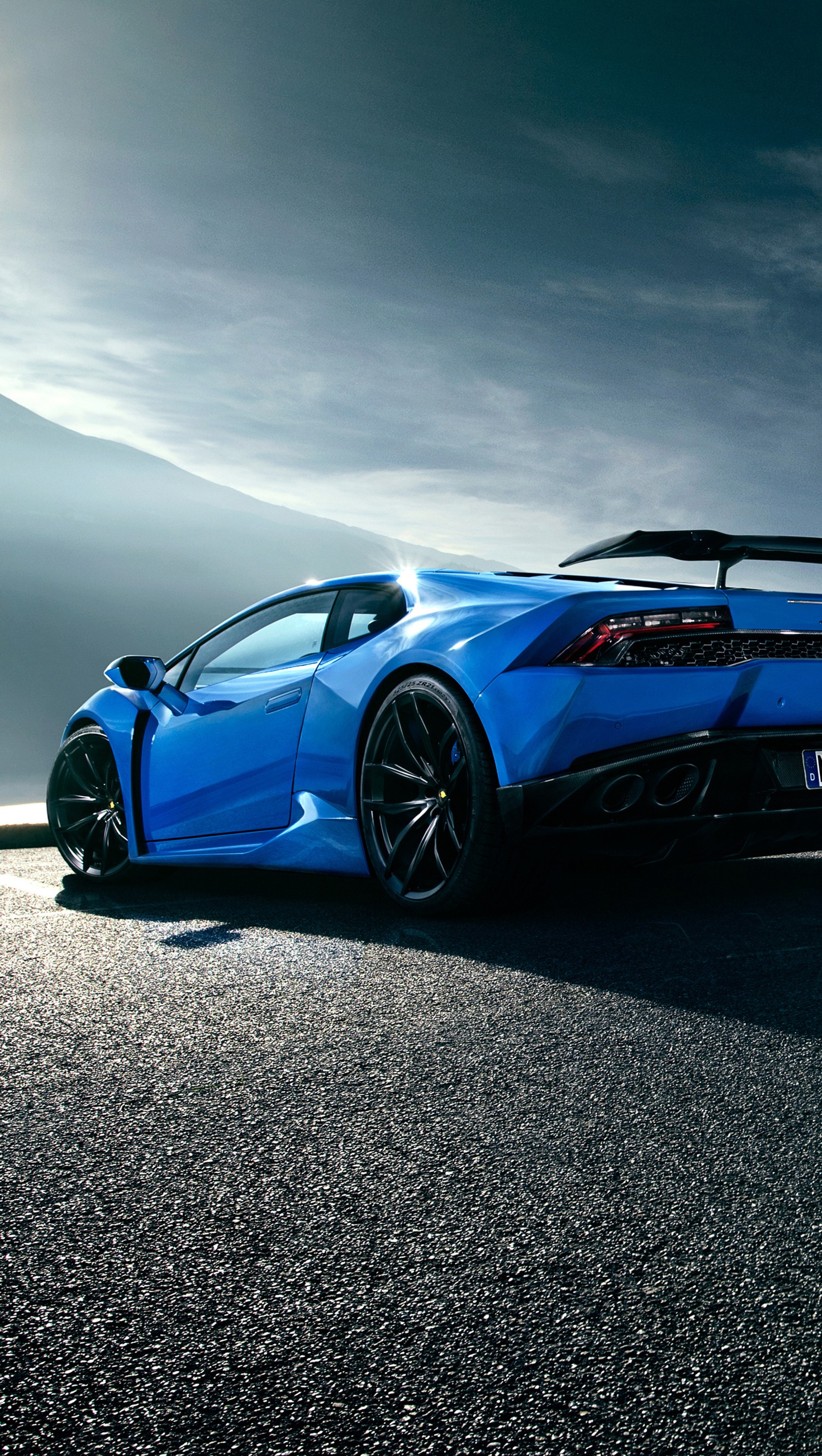 Eine nahaufnahme eines blauen sportwagens, der auf der straße parkt (huracan, lambo, lamborghini, novitec)