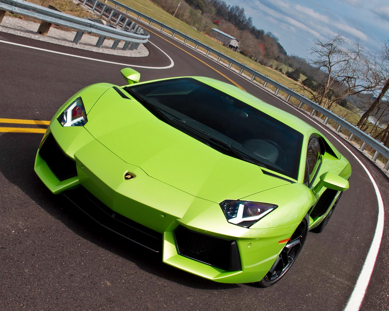 Un primer plano de un coche deportivo verde conduciendo por una carretera (coche, lamborghini)