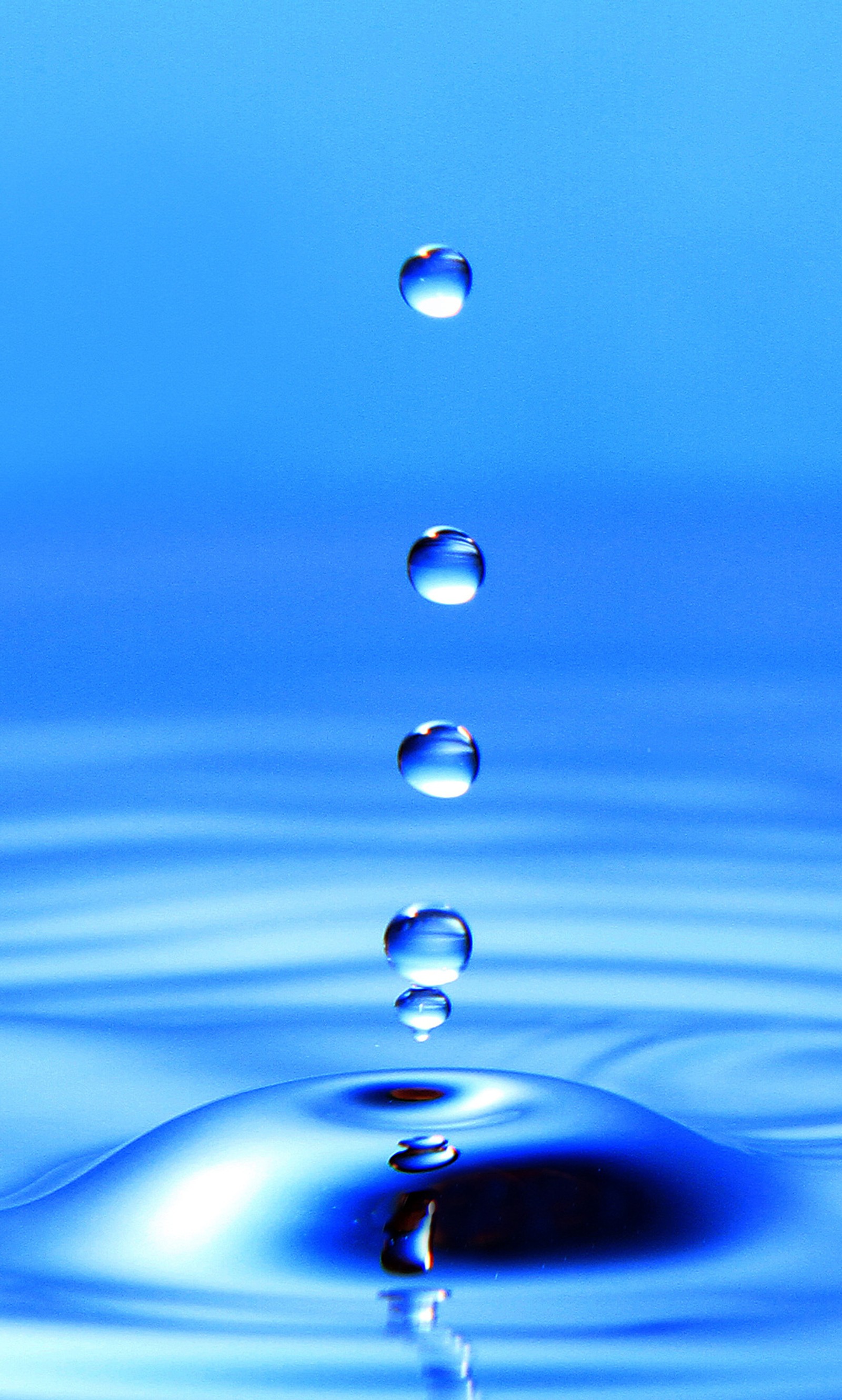 A close up of a drop of water falling into a body of water (blue drops, nice)