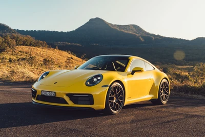 Porsche 911 Carrera GTS 2022 en Jaune Vibrant contre un Fond Montagnard Scénique