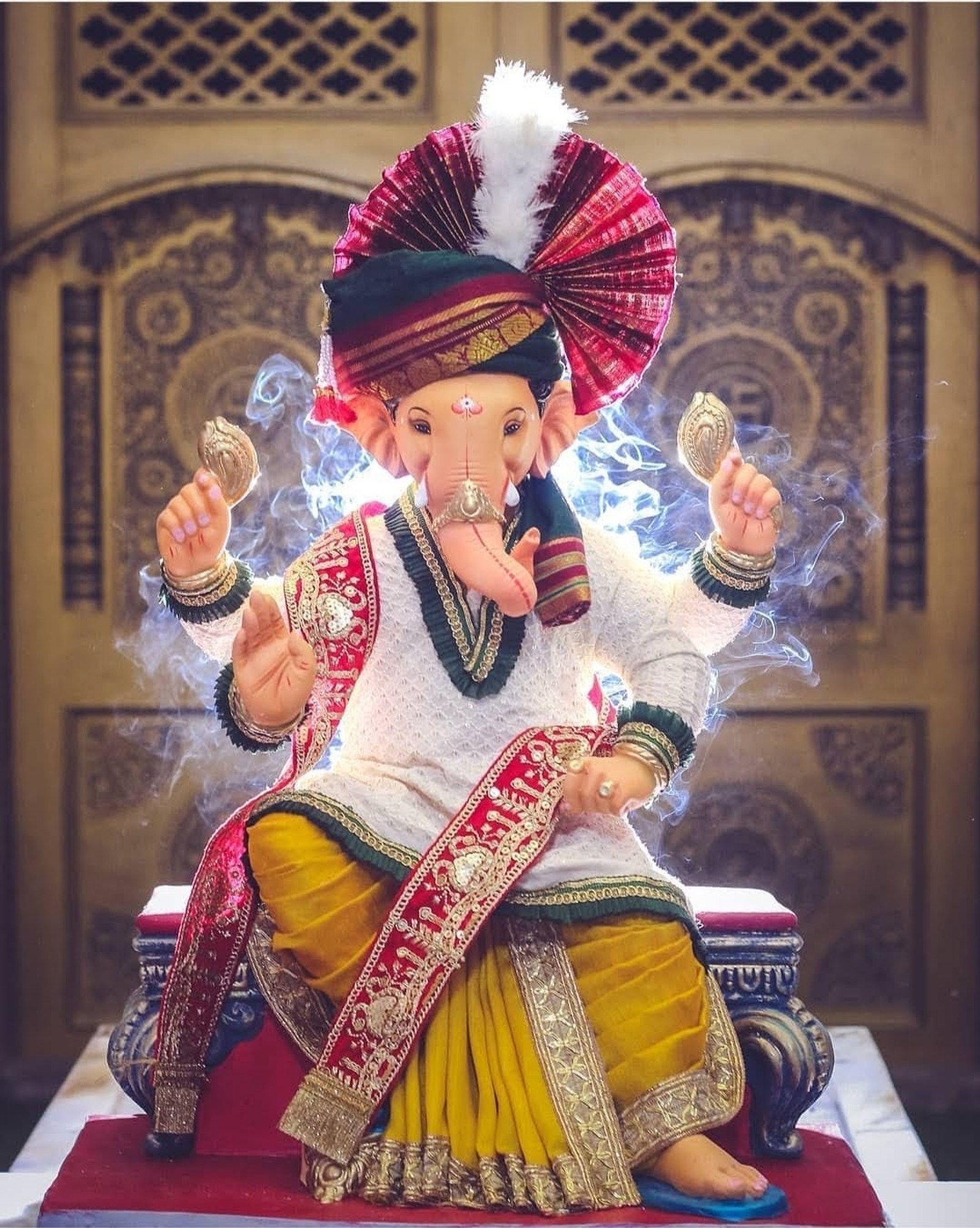 Eine statue von ganesh, die auf einem roten tisch sitzt (ganapati bappa morya, rajshahi ganpati bappa)