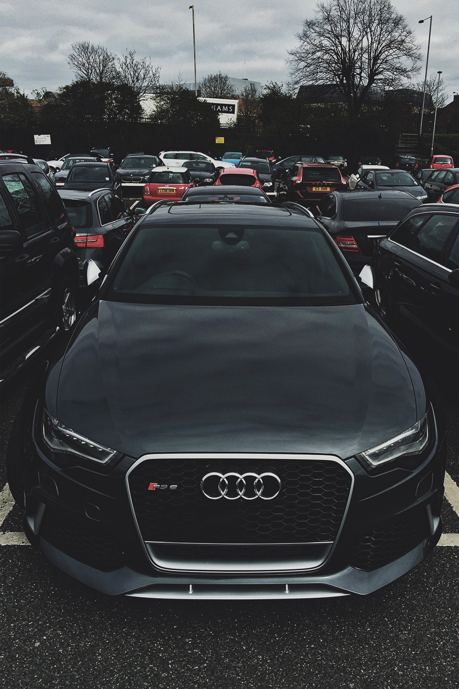 Une voiture audi garée dans un parking avec d'autres voitures en arrière-plan (audi car best, voitures, auto)