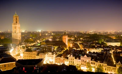 Paisaje urbano nocturno de una metrópoli con torres icónicas y horizonte