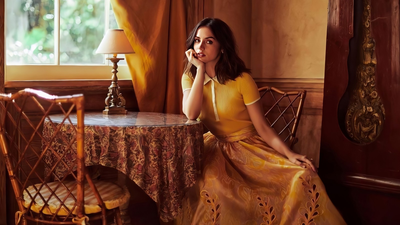 Une femme arabe assise à une table dans une robe jaune (ana de armas, cubain, espagnol, actrice, célébrité)