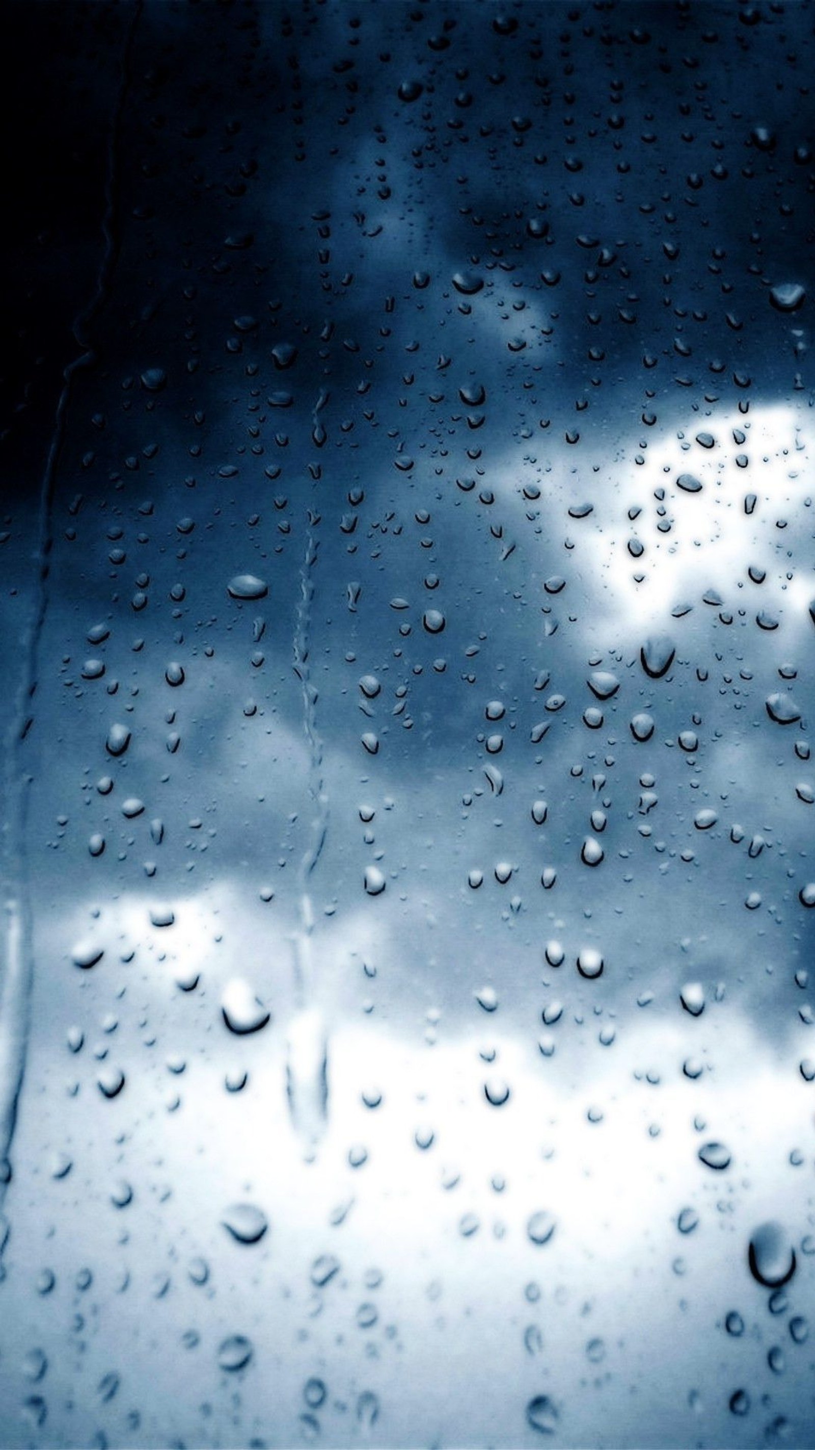 Un primer plano de una ventana cubierta de lluvia con gotas de lluvia (gotas, lluvia)