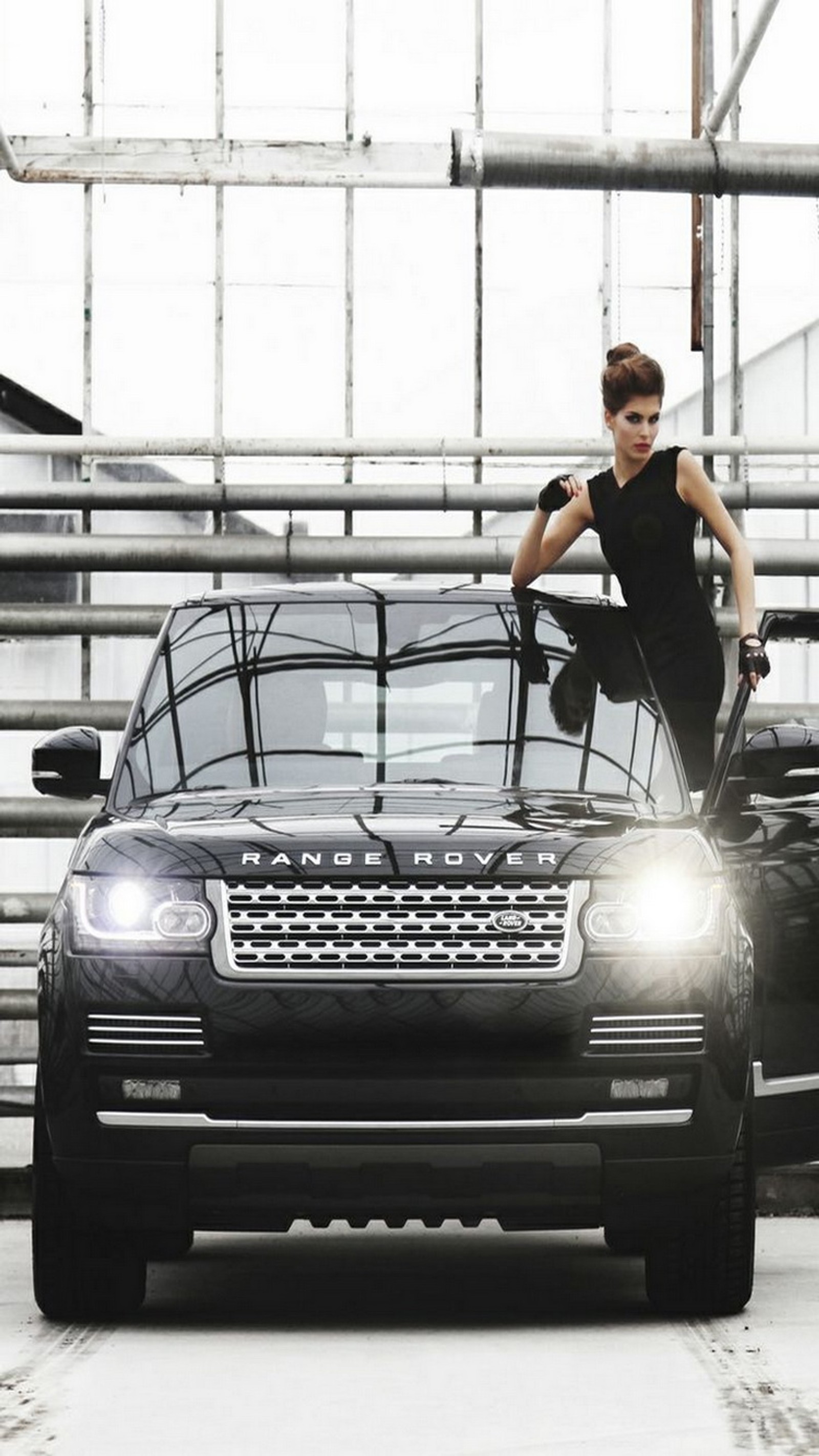 Arafed woman leaning on a car in a garage (model, range rover)