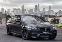 BMW M5 2018 em acabamento fosco com fundo de horizonte urbano