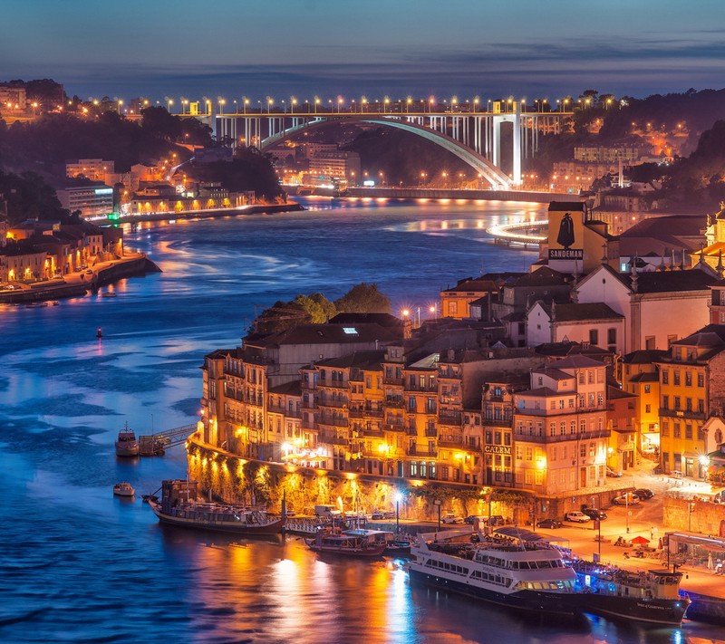 Vista aérea de uma cidade com uma ponte e um rio (arrabida, ponte, douro, luz, noite)