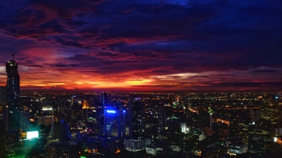 Cielo nocturno vibrante de una metrópoli contra un dramático atardecer