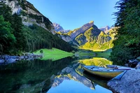 Serene Early Morning at Seealpsee Lake: Reflections of Majestic Peaks and a Rowing Boat in Switzerland