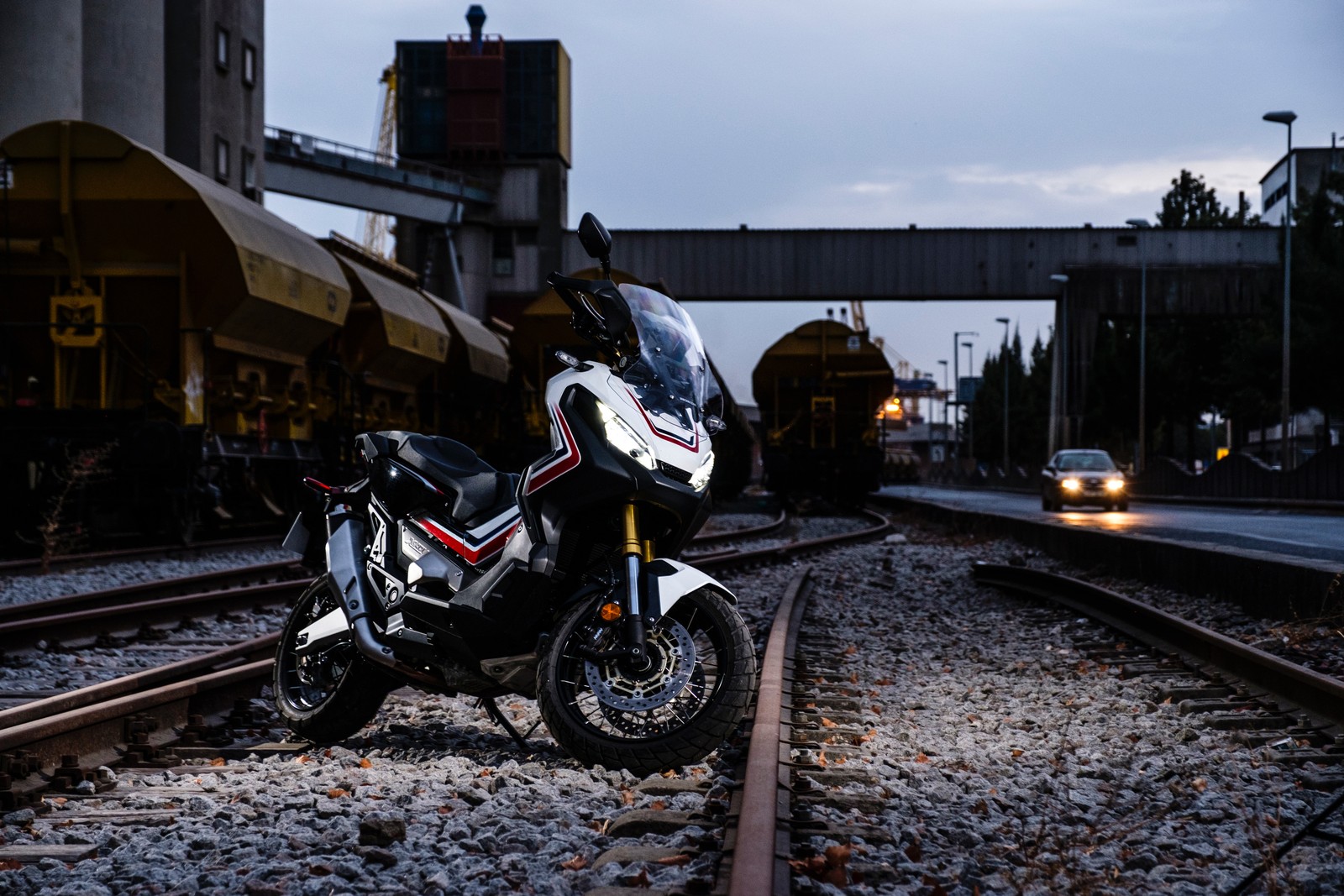 Uma motocicleta está estacionada nos trilhos perto de um trem (motocicleta, bicicleta, transporte, trilha, peça de automóvel)