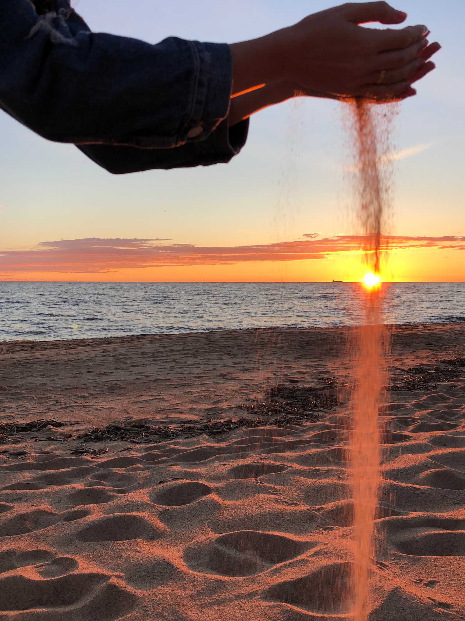 Alguém está despejando areia no ar na praia (mar, água, nascer do sol, corpo de água, líquido)