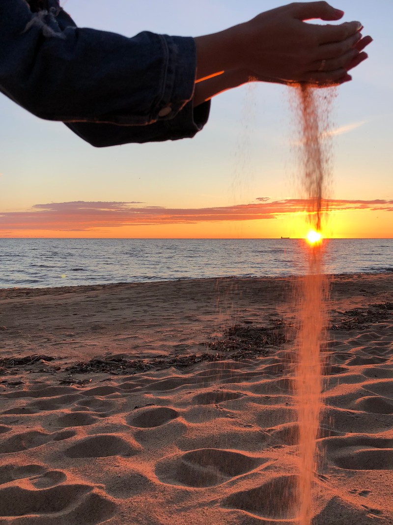 Кто-то разбрасывает песок в воздух на пляже (море, вода, восход солнца, водоем, жидкость)