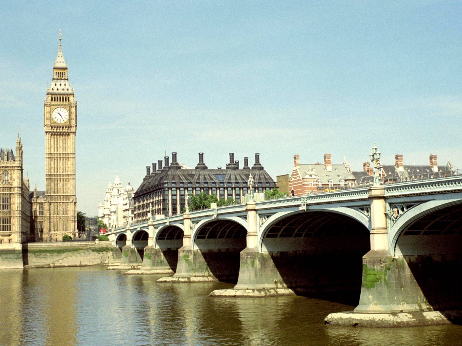 Puente araffe sobre un río con una torre del reloj al fondo (casas del parlamento, palacio de westminster, big ben, hito, puente)