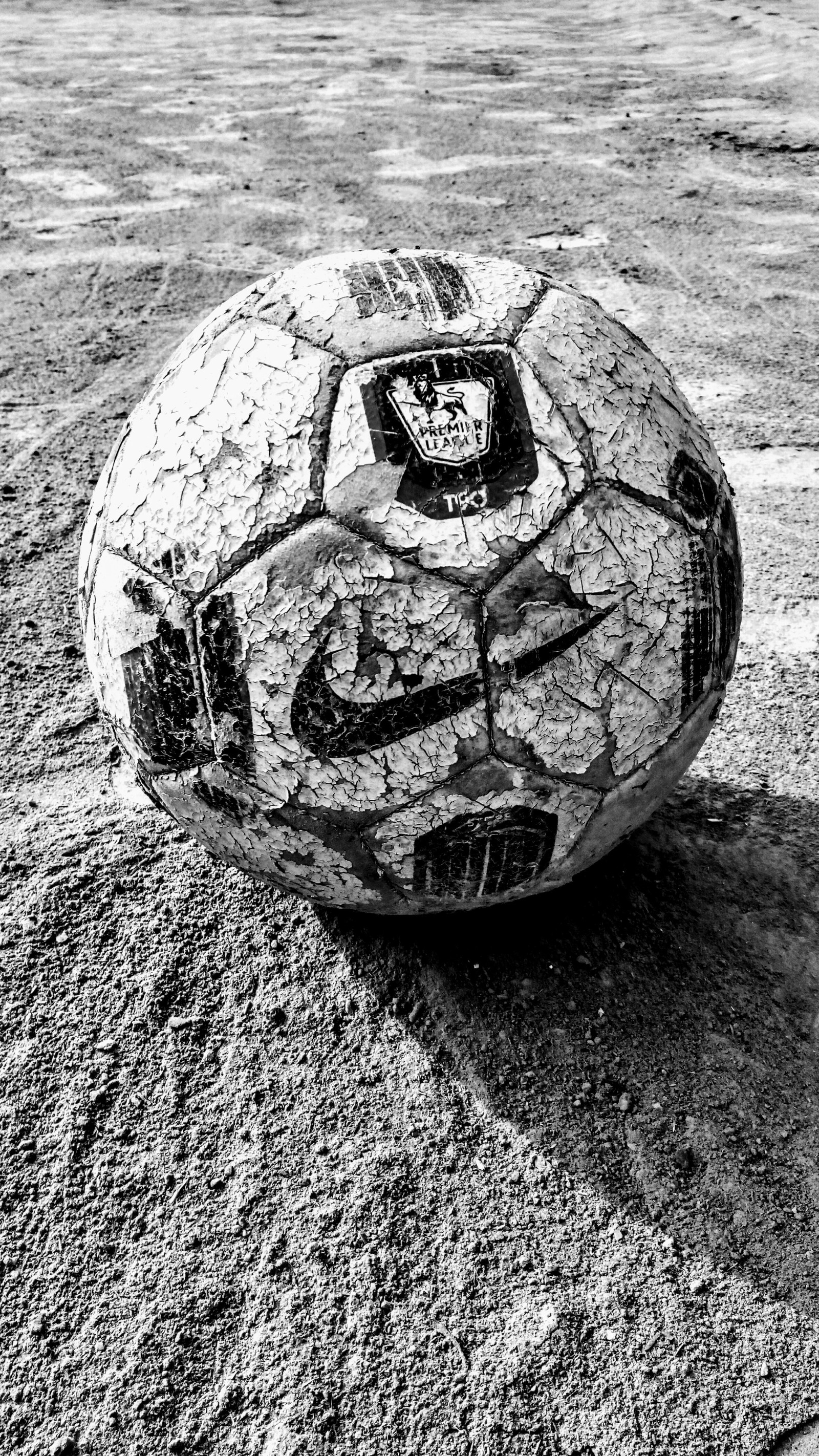 Una foto en blanco y negro de un balón de fútbol en un campo (fútbol, futbol)