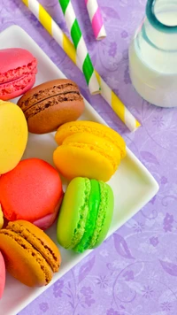 Macarons coloridos e doces em um prato com canudos e leite