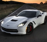 Eleganter weißer Chevrolet Corvette auf offener Straße bei Sonnenuntergang