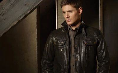 Dean Winchester em uma jaqueta de couro estilosa, exalando um visual robusto, mas sofisticado contra um fundo moderno.