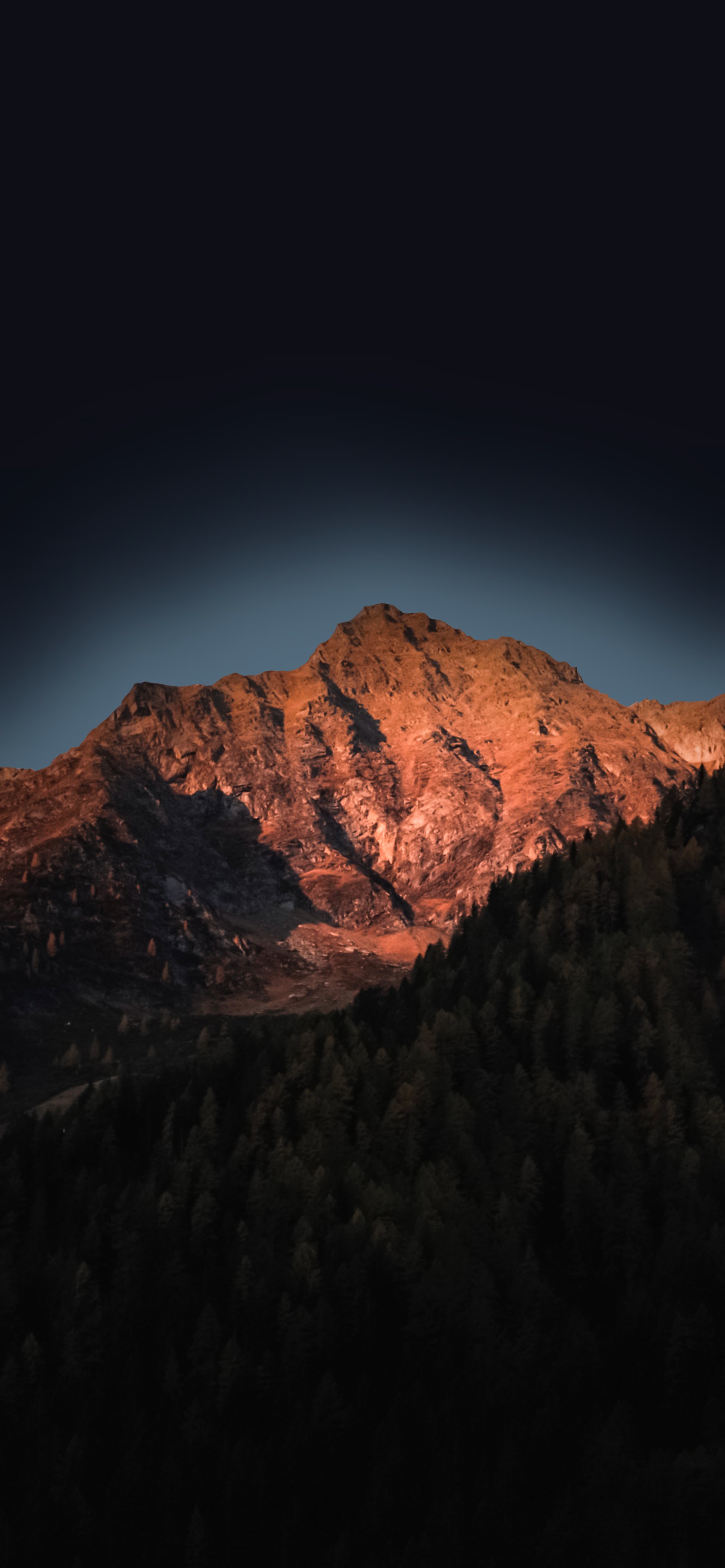 Mountains with a few trees and a dark sky in the background (apples, smartphone, mountain, atmosphere, cloud)