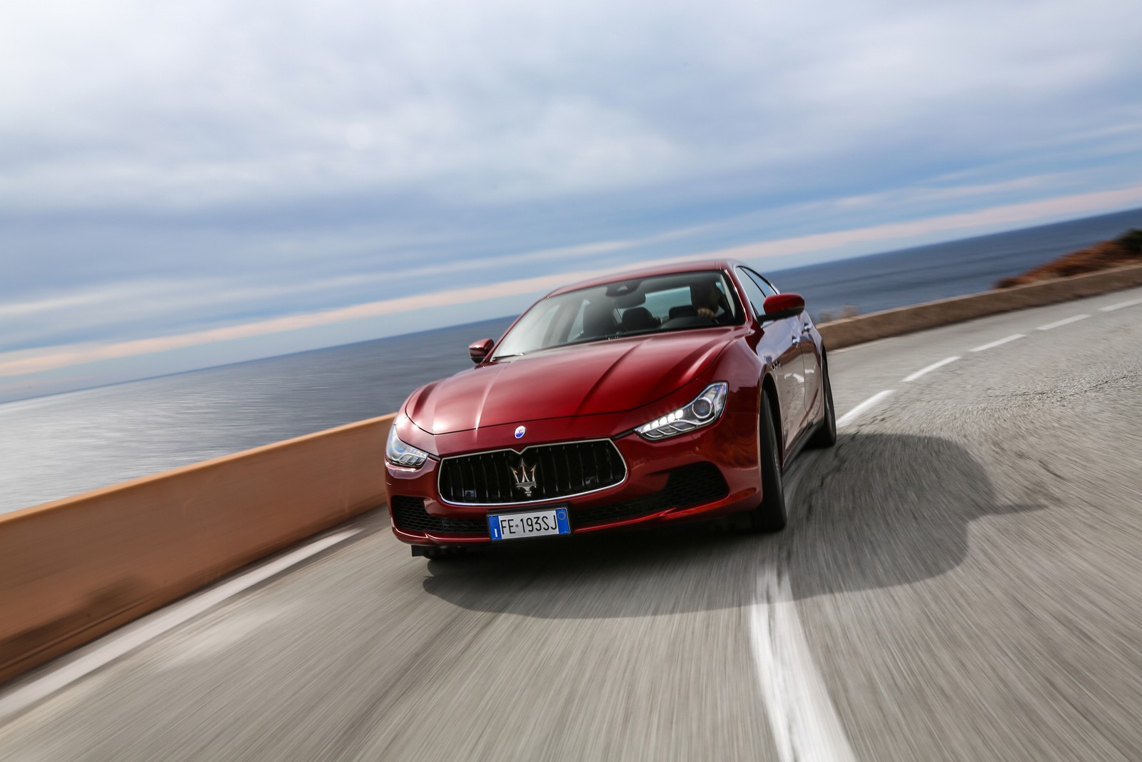 Nahaufnahme eines roten maserati, der auf einer straße am meer fährt (maserati, alfa romeo, auto, sportwagen, luxusauto)