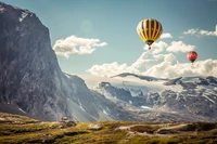 Vibrant Hot Air Balloons Soaring Over Majestic Mountain Range