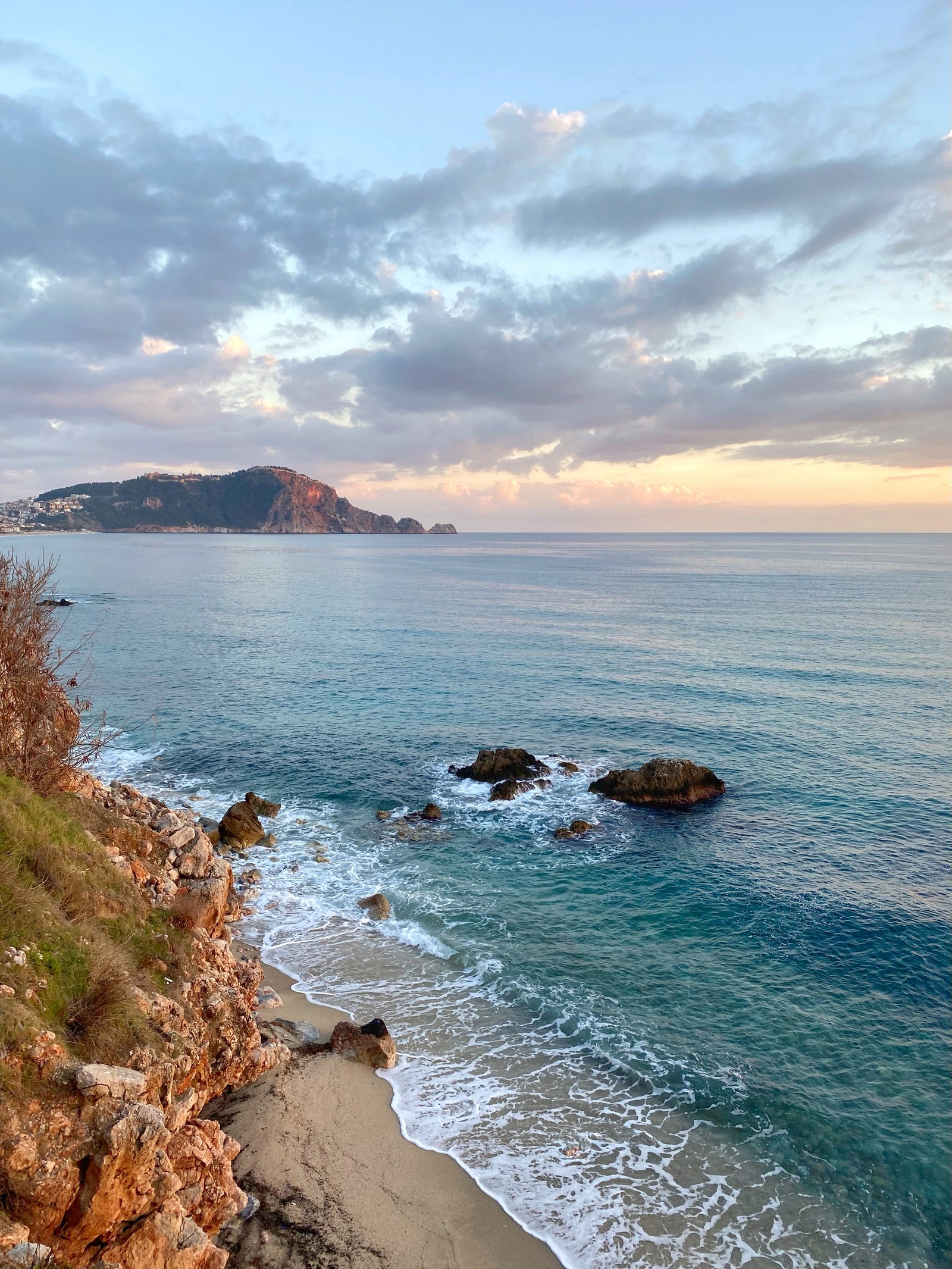 Il y a une vue sur une plage avec une falaise et un plan d'eau (mer, eau, nuage, ressources en eau, azur)