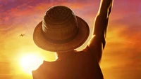 Monkey D. Luffy levantando seu braço contra um vibrante pôr do sol em One Piece live action