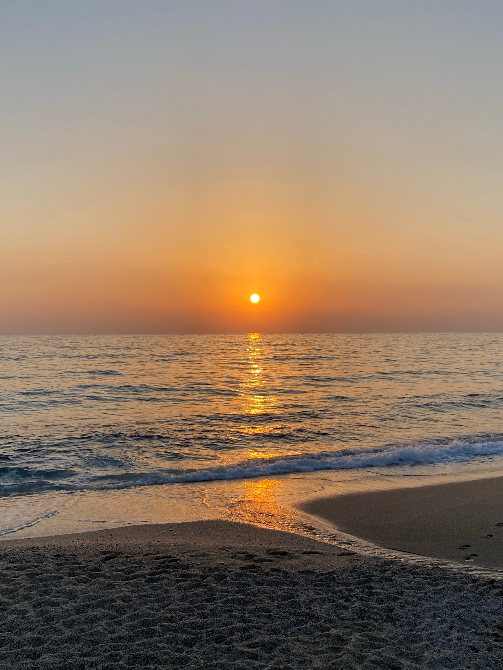 Coucher de soleil sur l'océan avec une personne marchant sur la plage (coucher de soleil, eau, fluide, crépuscule, ensoleillement)