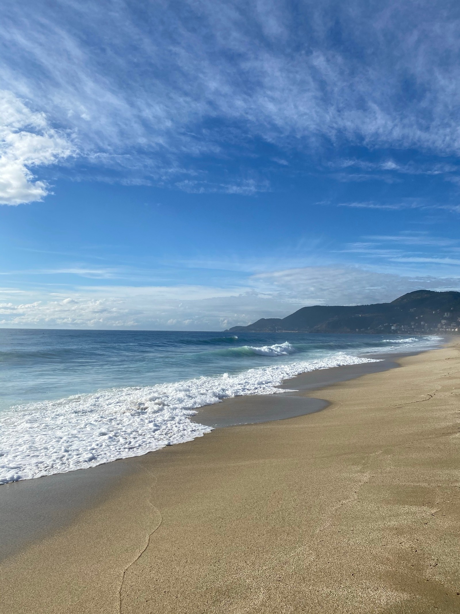 Hay una persona caminando por la playa con una tabla de surf (mar, nube, agua, ecorregión, playa)