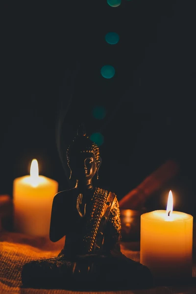 Statue de Bouddha sereine entourée d'une douce lumière de bougies