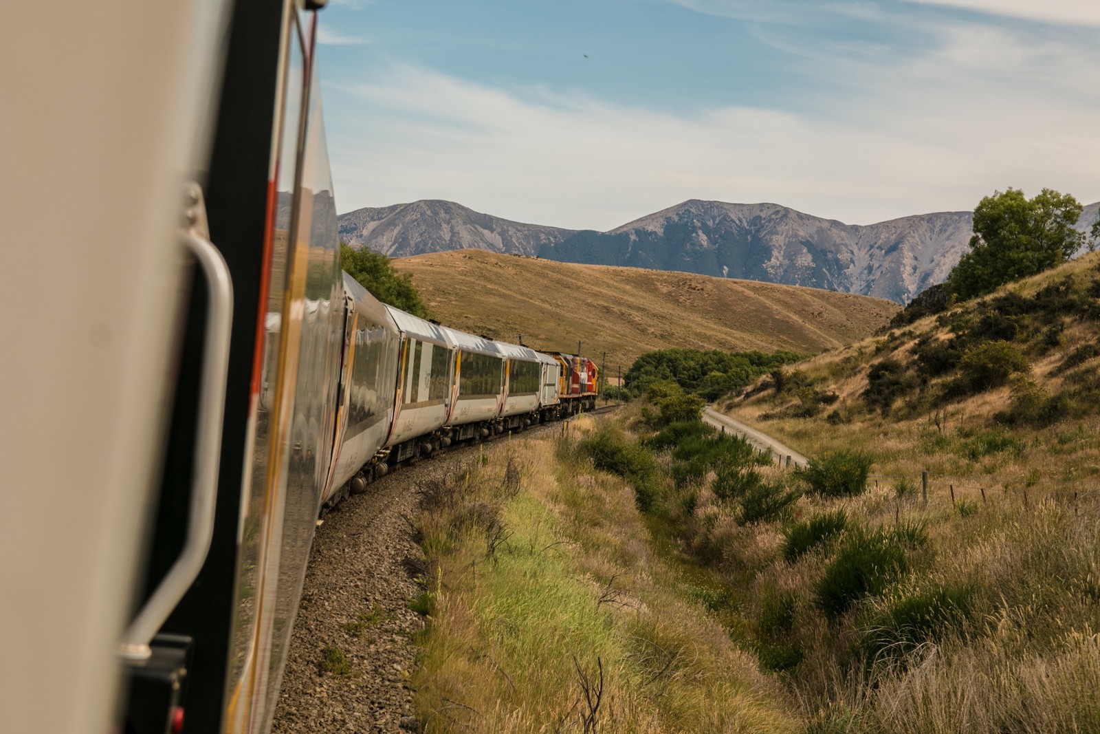 Hay un tren que viaja por las vías en las montañas (viajar, nuevo lugar, emocionante, ir)