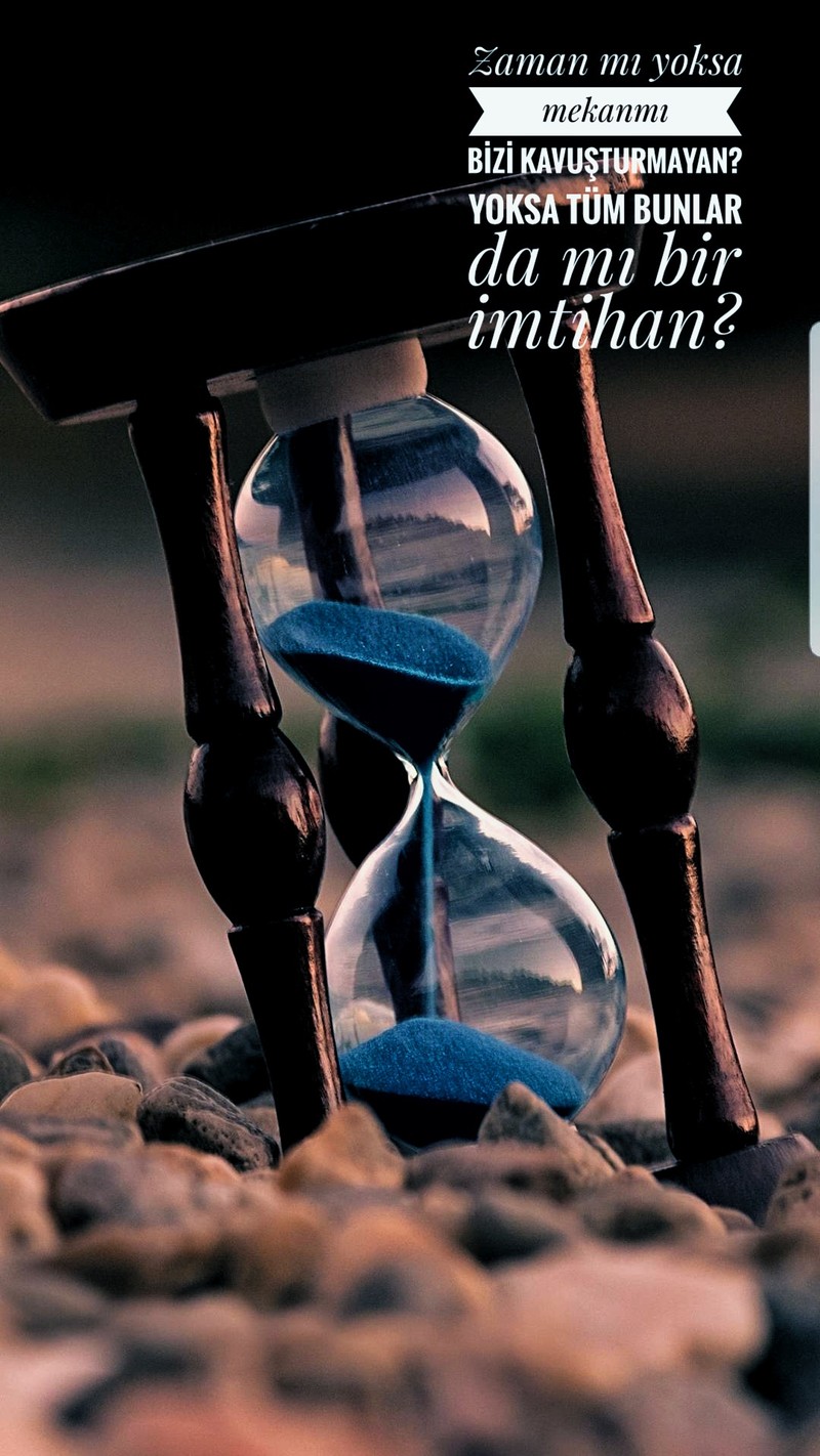 There is a hourglass with sand running through it on a rocky ground (imtihan, time)