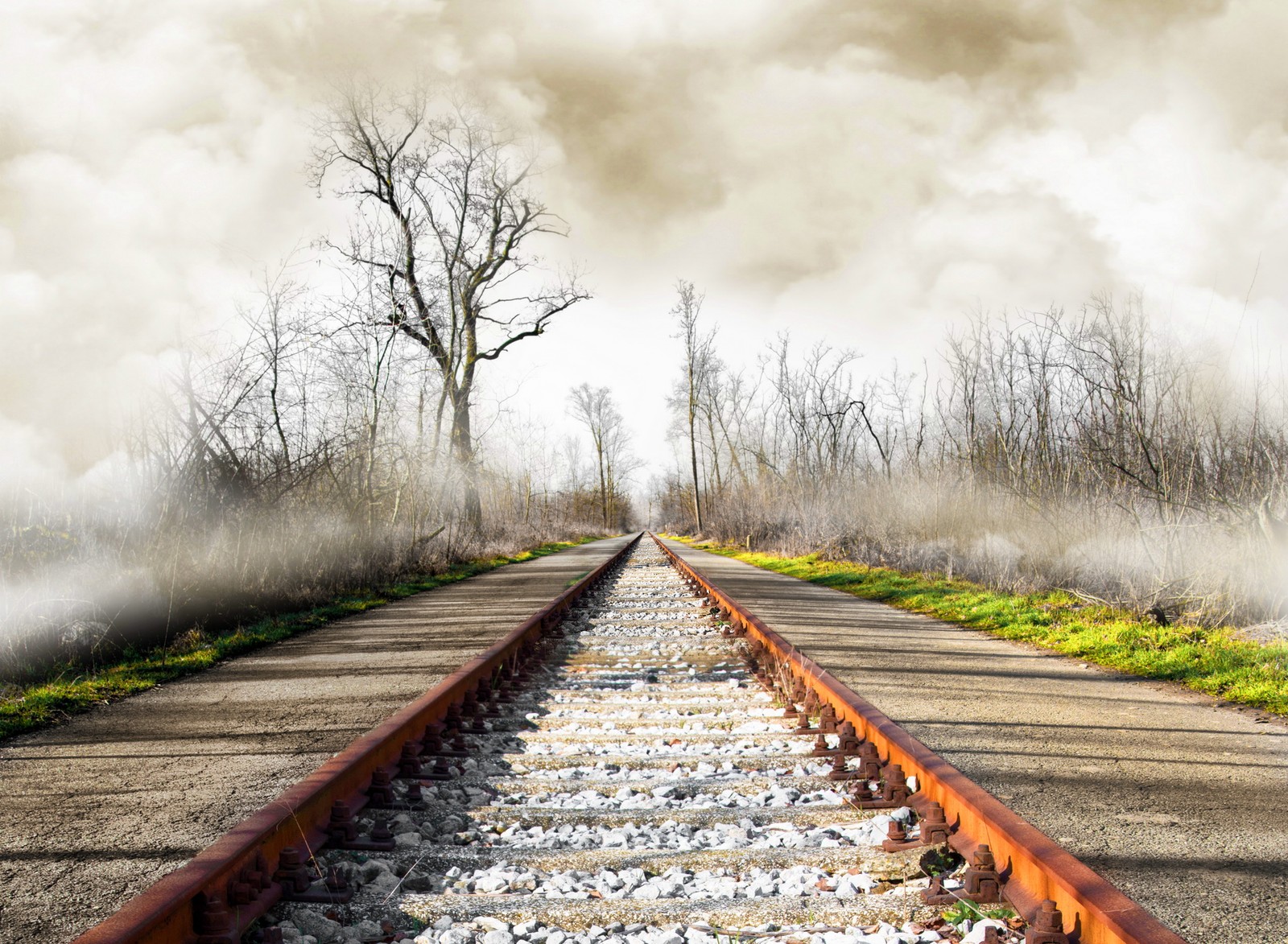 There is a train track that is going down the tracks (clouds, foggy, nature, railway, sky)