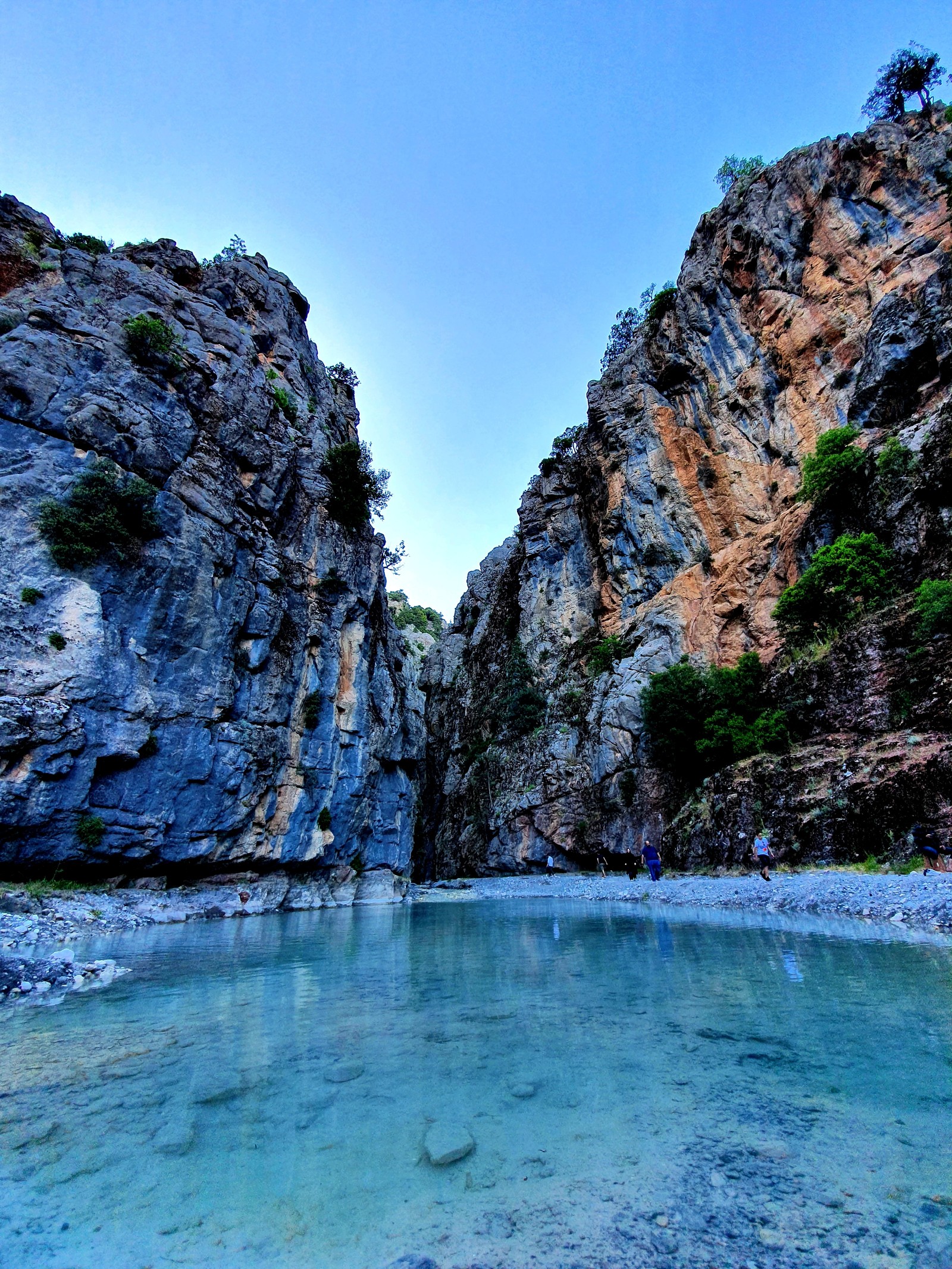 Il y a un homme debout dans l'eau près d'une montagne (akarsu, bleu, dag, doga, kanyon)