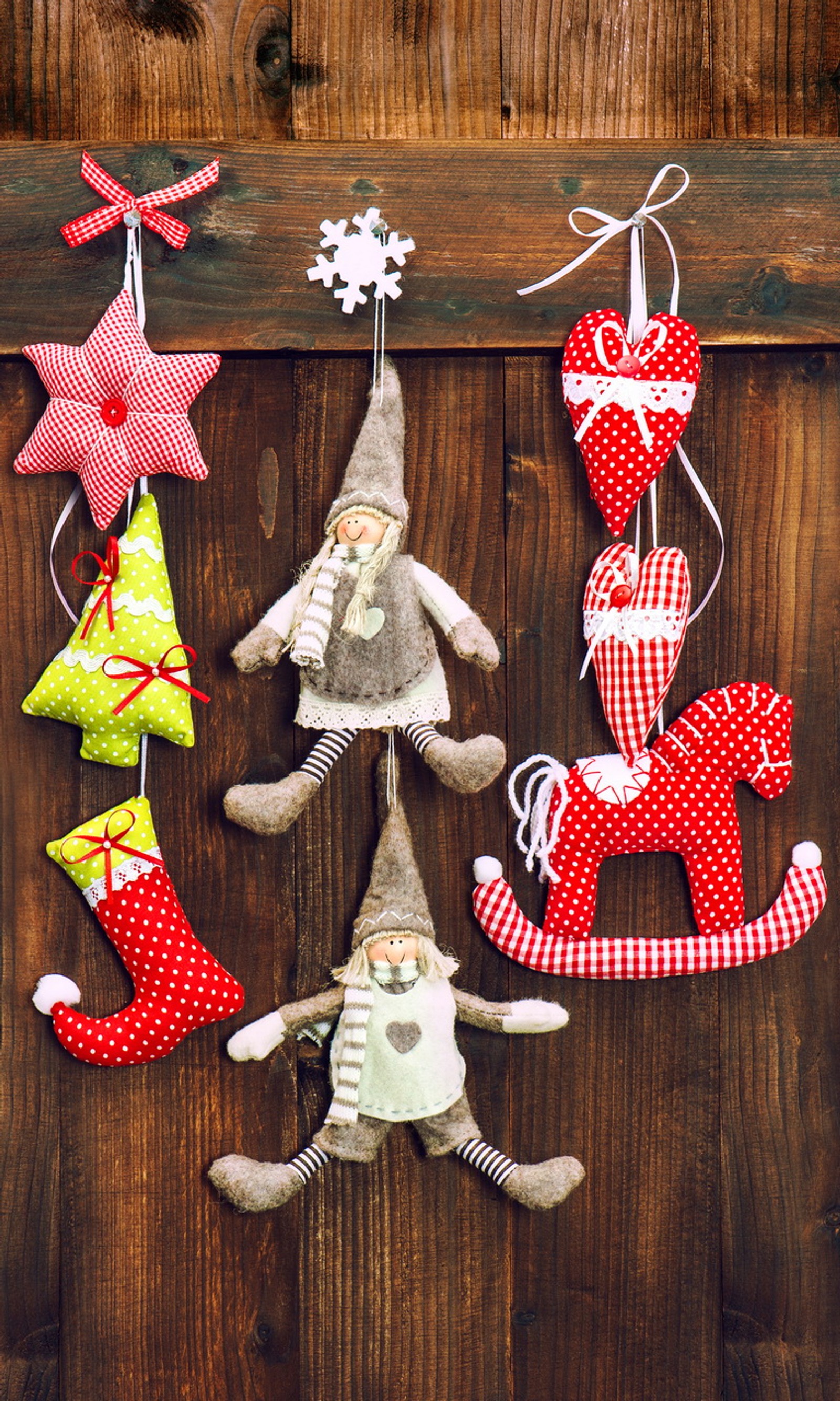 There are many ornaments hanging on a wooden wall (christmas decoration, wooden background)