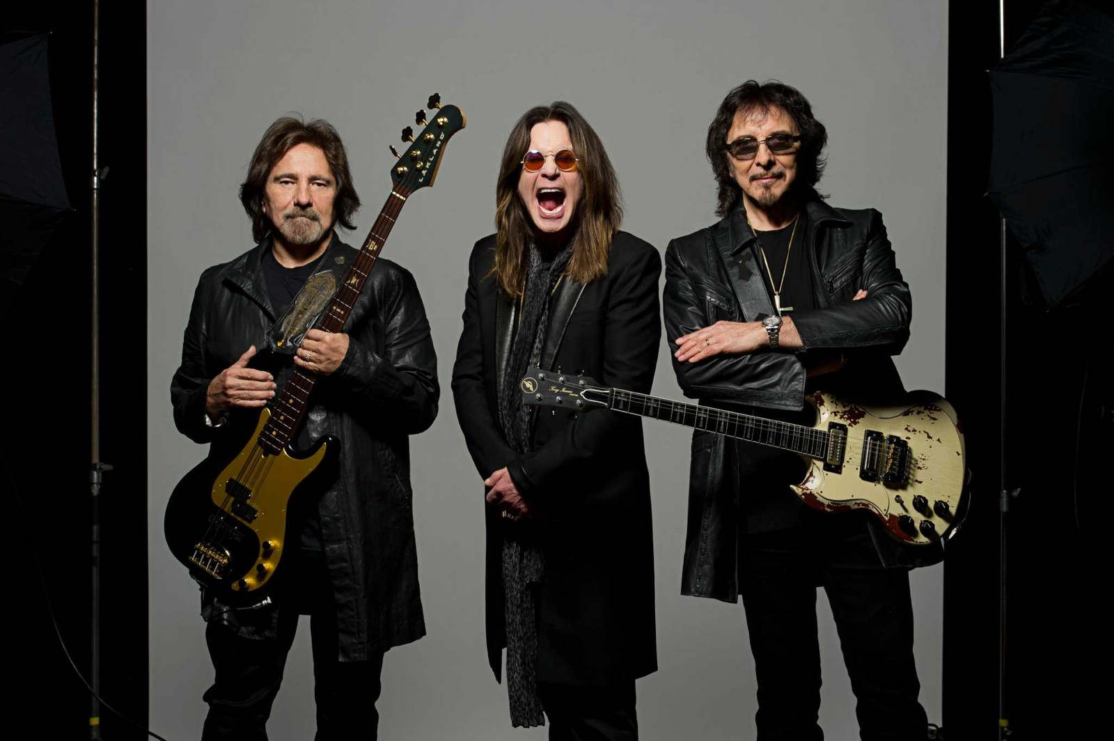 Arafed image of three men with guitars posing for a picture (ozzy osbourne, tony iommi, geezer butler, black sabbath, musician)