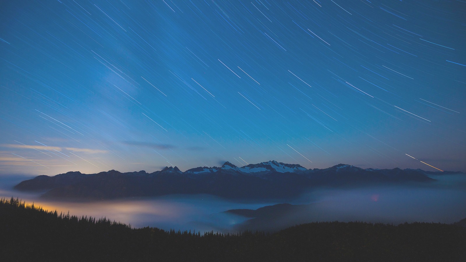 Vue d'une chaîne de montagnes avec une traînée d'étoiles au-dessus (paysage, nature, montagne, nuage, atmosphère)