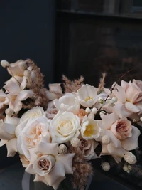 Elegant bouquet of soft pink and white roses, complemented by delicate accents and natural elements, showcasing the art of floral design.