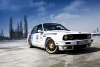 BMW E30 M3 en icónica librea de motorsport, mostrando su herencia de carreras y diseño deportivo contra un cielo dramático.