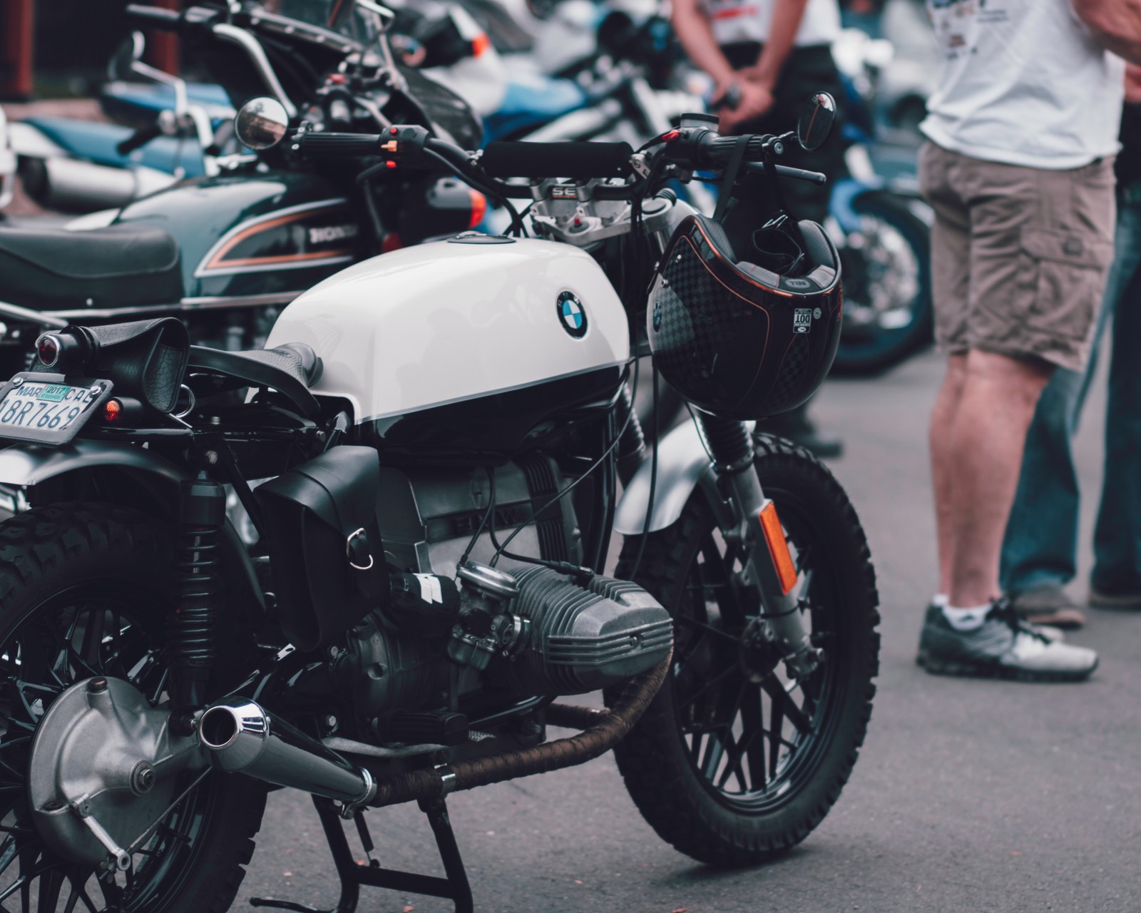 Motos garées sur le bord de la route avec des gens debout autour (moto, vélo, voiture, pièce automobile, motocyclisme)