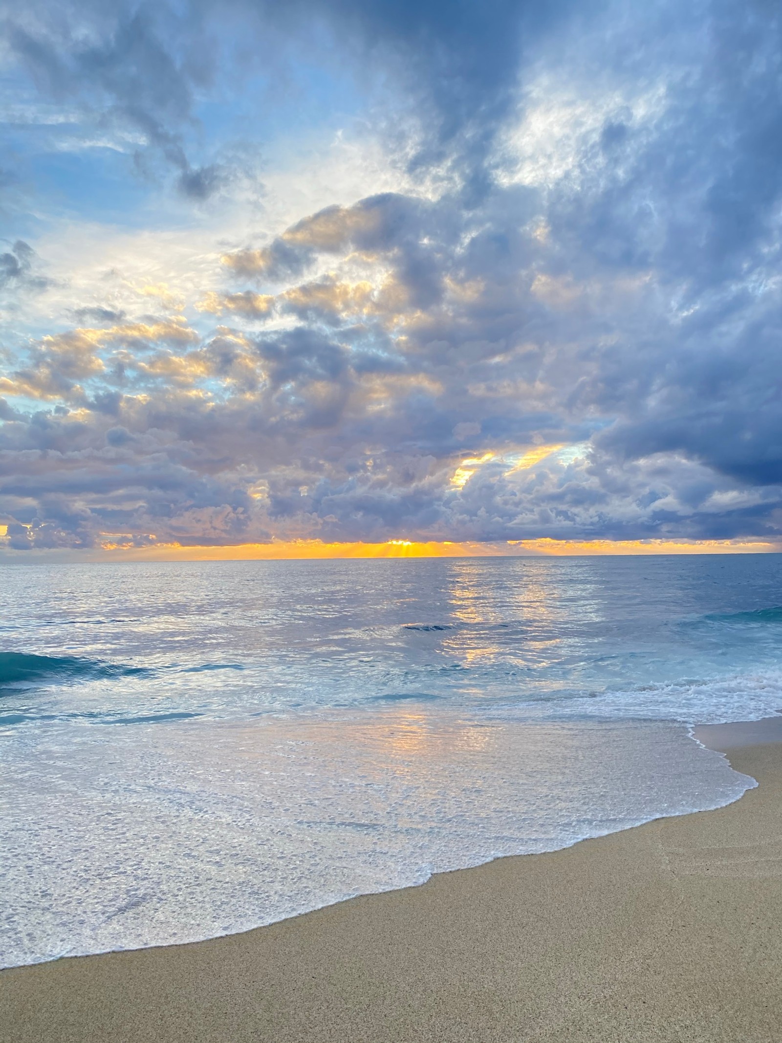 Il y a une planche de surf solitaire sur la plage au coucher du soleil (mer, science, physique, nuage, eau)