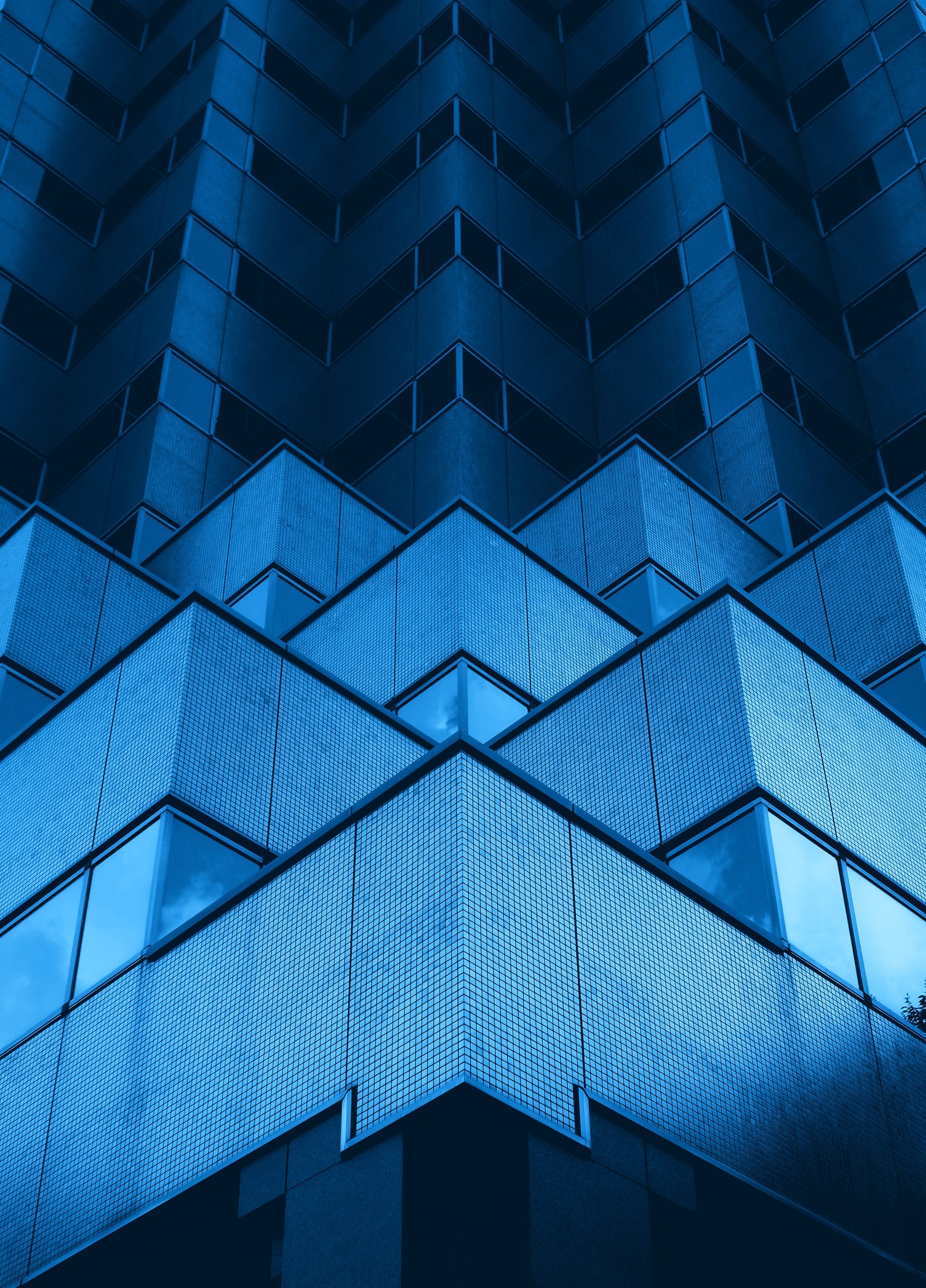 Arafed-blick auf ein hohes gebäude mit blauem himmel im hintergrund (moderne architektur, gebäude, büro, geometrisch, blauer hintergrund)