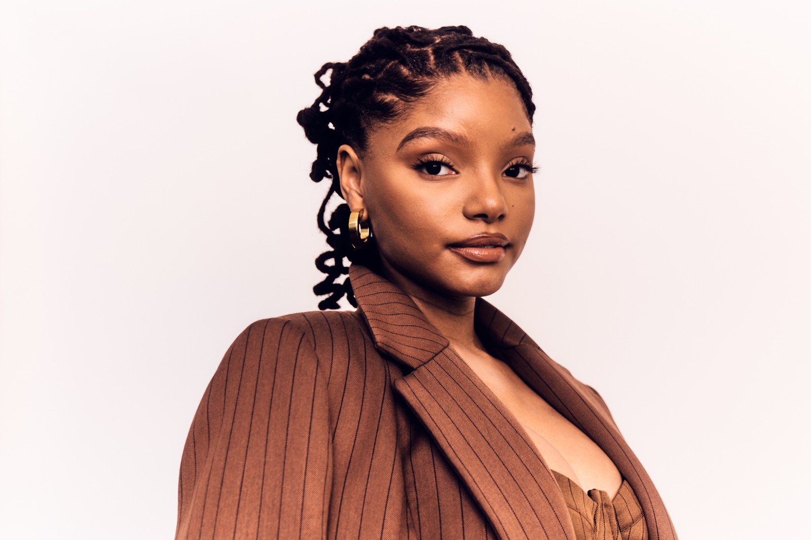 Une femme avec une veste marron et un haut marron (halle bailey, actrice américaine, gens, fond décran 4k)